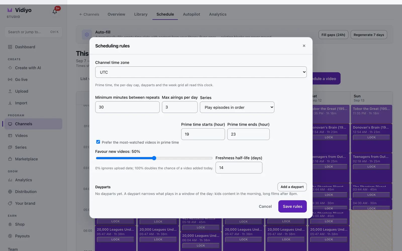 The Scheduling rules dialog over the week grid: Channel time zone set to UTC, Minimum minutes between repeats 30, Max airings per day 3, prime time 19 to 23, a Favour new videos slider at 50%, and an empty Dayparts section with an Add a daypart button.